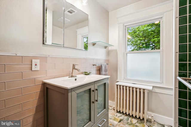 4311 Ellicott St NW, Washington, DC 20016 - bathroom featuring radiator heating unit, plenty of natural light, tile walls, vanity, and wainscoting