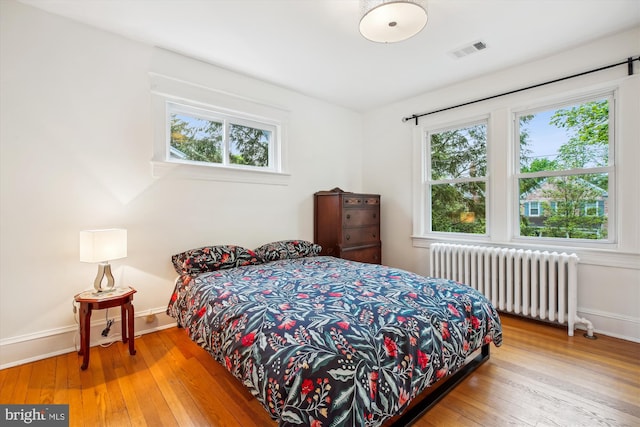 4311 Ellicott St NW, Washington, DC 20016 - bedroom with radiator heating unit, wood-type flooring, and baseboards