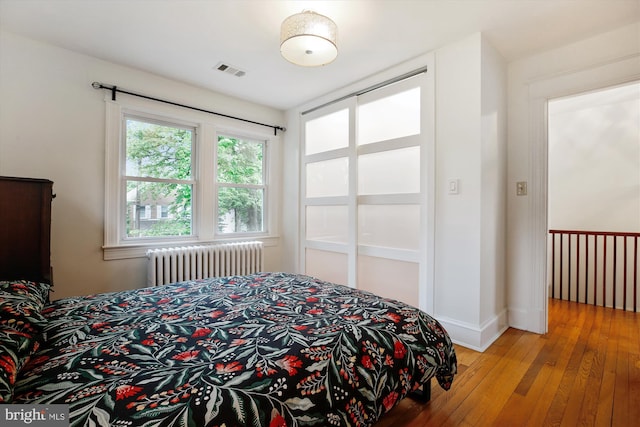 4311 Ellicott St NW, Washington, DC 20016 - bedroom featuring radiator heating unit, light wood-style flooring, and baseboards