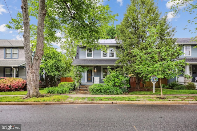 4311 Ellicott St NW, Washington, DC 20016 - view of front of house with solar panels, covered porch, and fence