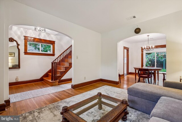 4311 Ellicott St NW, Washington, DC 20016 - living area featuring a chandelier, hardwood / wood-style flooring, arched walkways, and baseboards
