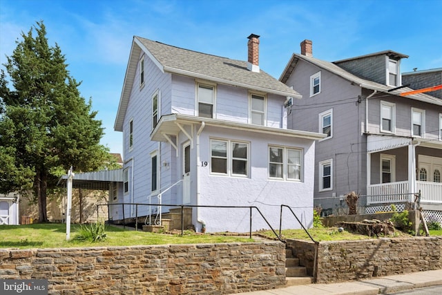 american foursquare style home featuring a chimney and entry steps