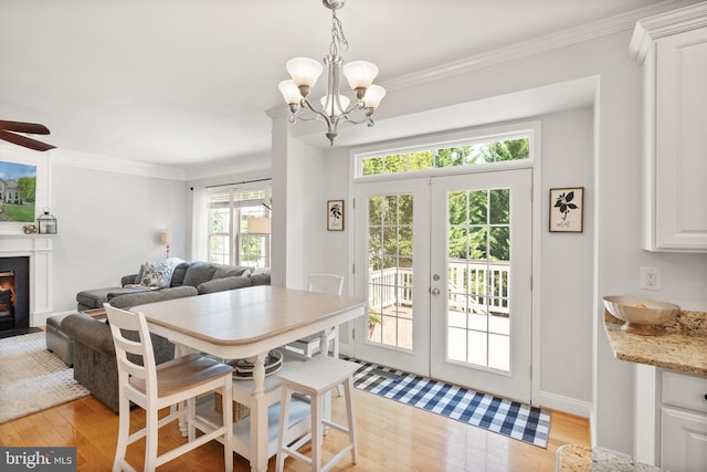 dining space featuring ornamental molding, light wood-type flooring, and french doors
