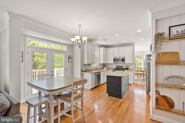 kitchen with a kitchen island, crown molding, stainless steel appliances, and a sink