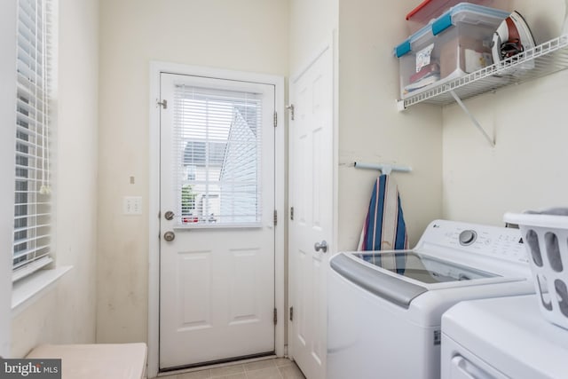 laundry area featuring washing machine and clothes dryer and light tile patterned floors