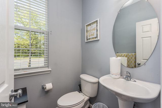 half bath featuring toilet and a sink