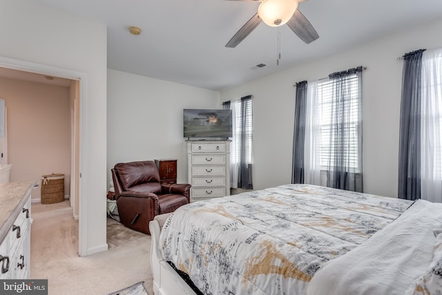 bedroom featuring light carpet and a ceiling fan