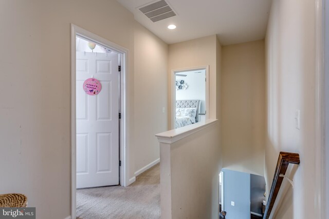 hallway with carpet, an upstairs landing, and baseboards