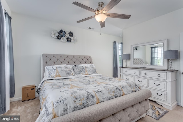 bedroom featuring light colored carpet, a ceiling fan, and baseboards