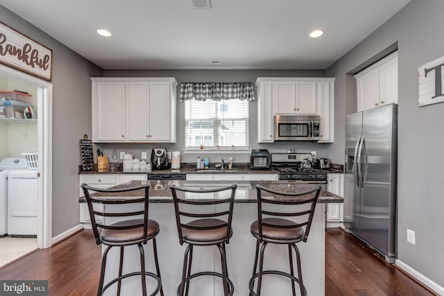 kitchen with stainless steel appliances, separate washer and dryer, white cabinets, dark wood-style floors, and recessed lighting