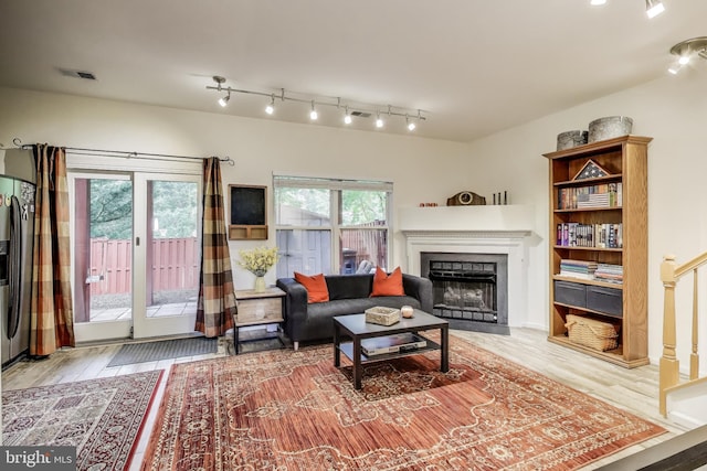 living area with visible vents, wood finished floors, and a fireplace