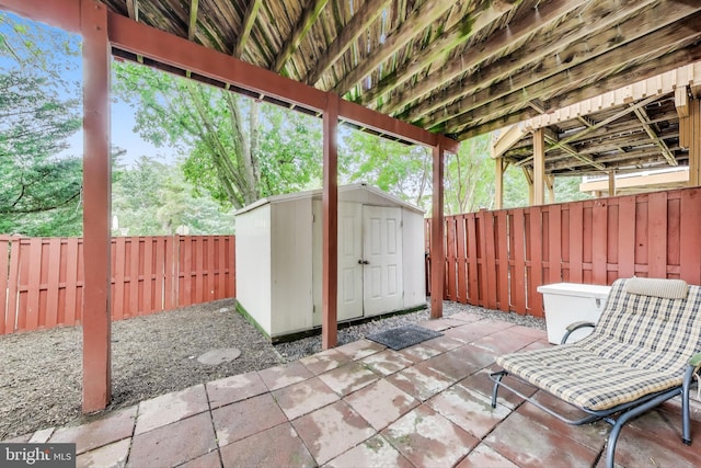 view of patio with a storage unit, an outdoor structure, and a fenced backyard