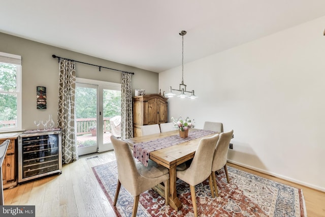 dining room featuring plenty of natural light, light wood-type flooring, and beverage cooler