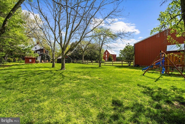 view of yard with an outdoor structure, a playground, and an outbuilding