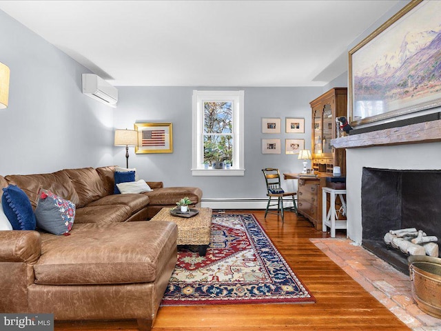 living room featuring a baseboard heating unit, an AC wall unit, wood finished floors, and a fireplace with flush hearth