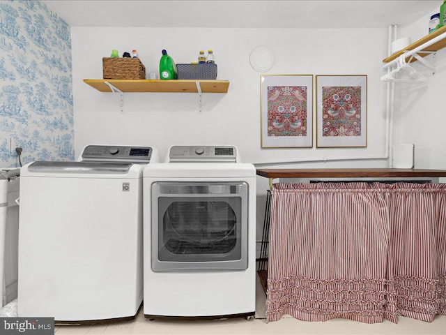 laundry area with washing machine and dryer and wallpapered walls