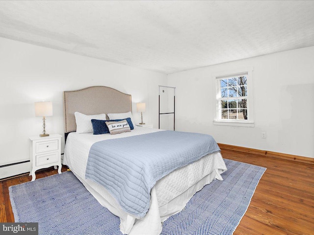 bedroom featuring wood finished floors and baseboards