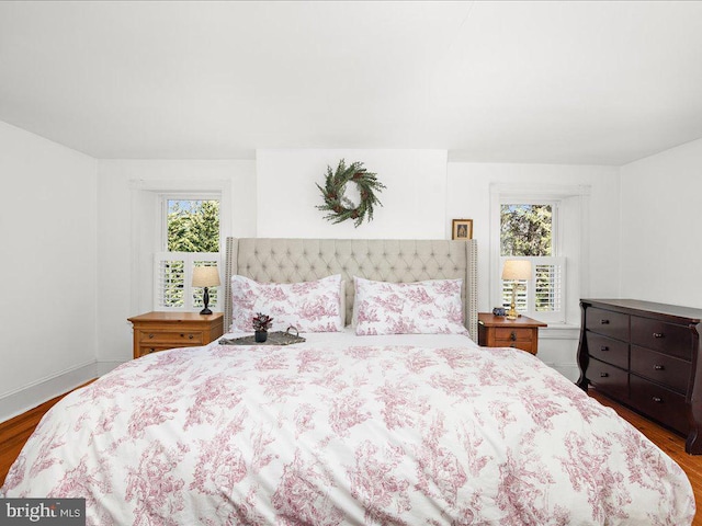 bedroom featuring multiple windows and wood finished floors