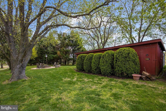 view of green lawn featuring an outbuilding