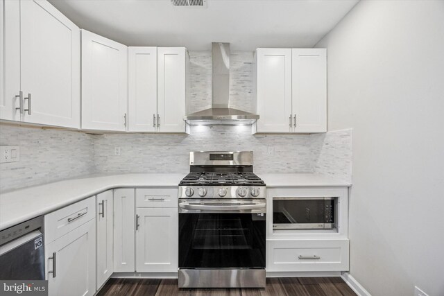 417 Jamestown Ct, Mount Laurel, NJ 08054 - kitchen featuring wall chimney range hood, stainless steel appliances, dark wood-style flooring, white cabinetry, and light countertops