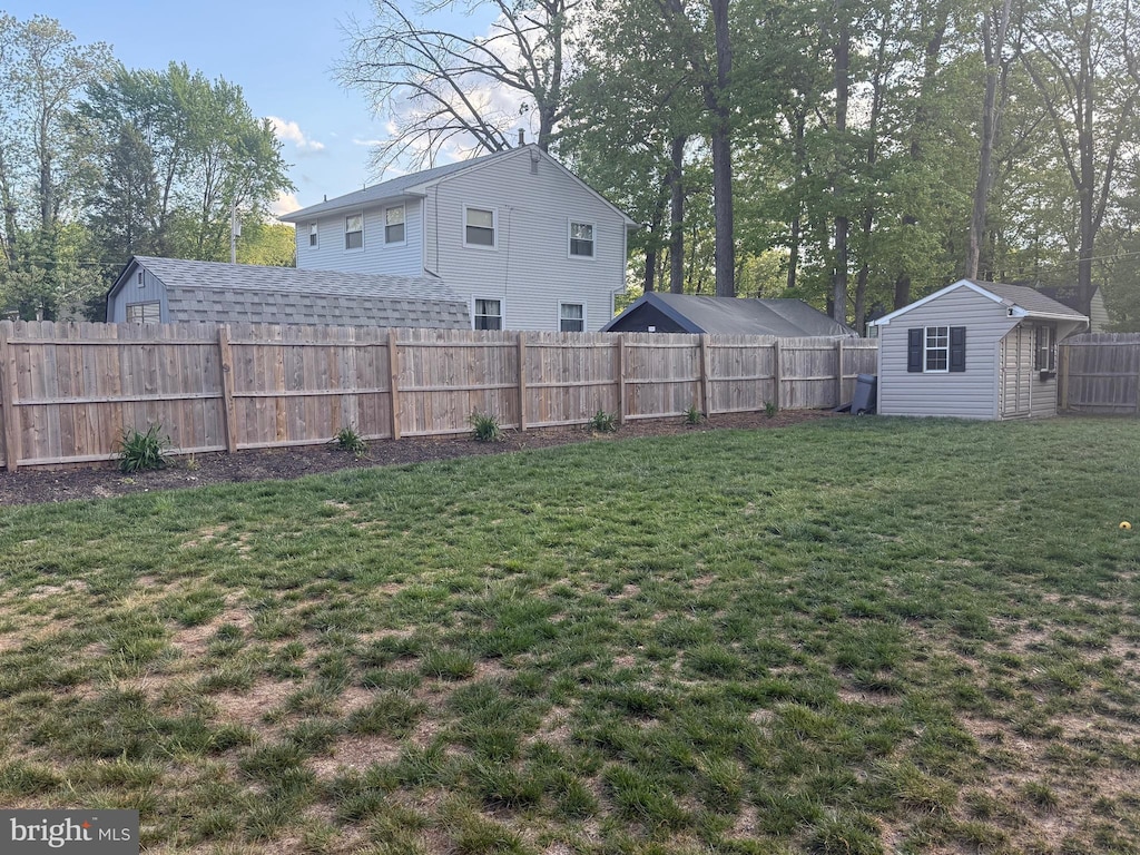 view of yard featuring an outbuilding, a shed, and a fenced backyard