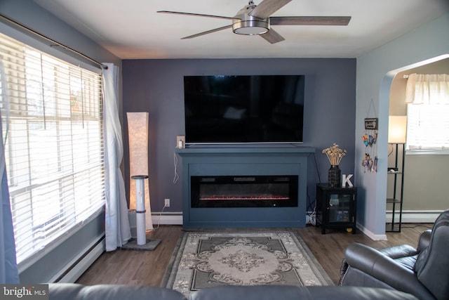 20 Fredericksville Rd, Mertztown, PA 19539 - living area featuring baseboard heating, a ceiling fan, a glass covered fireplace, and wood finished floors