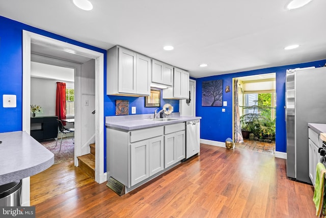 kitchen featuring appliances with stainless steel finishes, light countertops, baseboards, wood finished floors, and recessed lighting