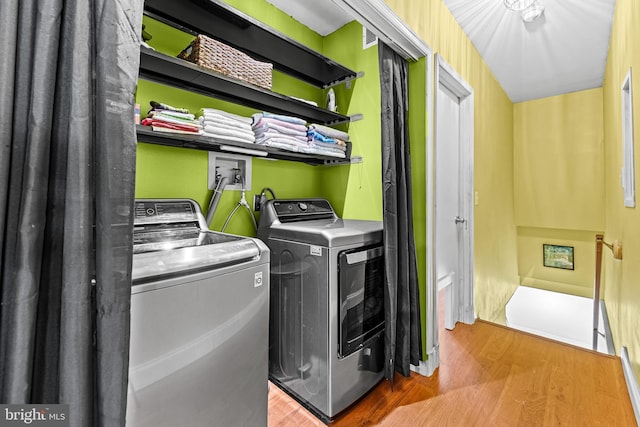 laundry room featuring washer and clothes dryer and wood finished floors