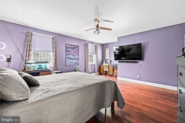 bedroom featuring wood finished floors, baseboards, and ceiling fan