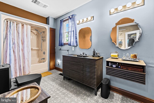 bathroom with vanity, shower / tub combo, and baseboards