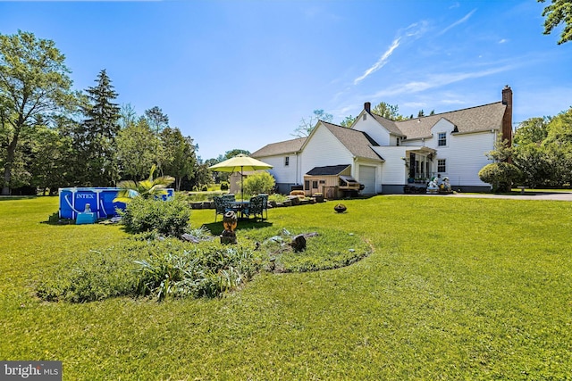 view of green lawn with an attached garage