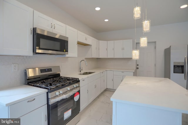 kitchen featuring stainless steel appliances, a sink, light marble finish floors, a center island, and recessed lighting