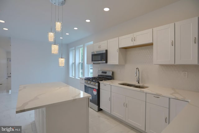 kitchen with stainless steel appliances, a sink, white cabinetry, recessed lighting, and light marble finish floors