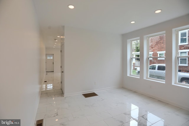 unfurnished room featuring recessed lighting, baseboards, and light marble finish floors