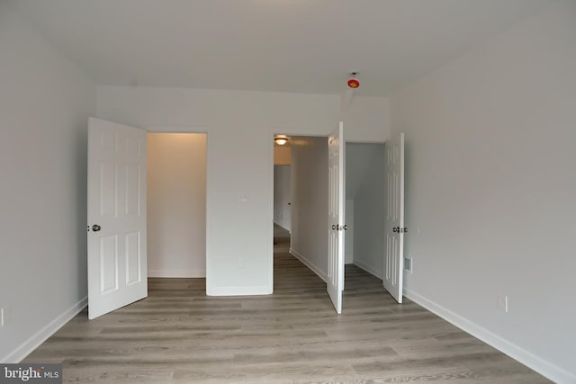 unfurnished bedroom with light wood-type flooring and baseboards