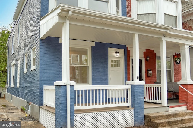 view of front of property featuring brick siding and a porch