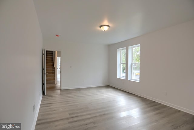 spare room featuring wood finished floors and baseboards