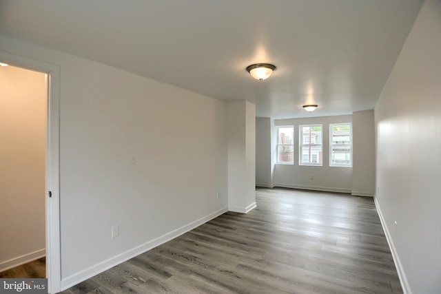unfurnished room featuring dark wood-style floors and baseboards