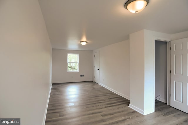 unfurnished room with wood finished floors and baseboards