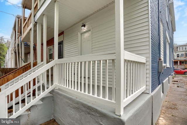 view of side of home featuring covered porch