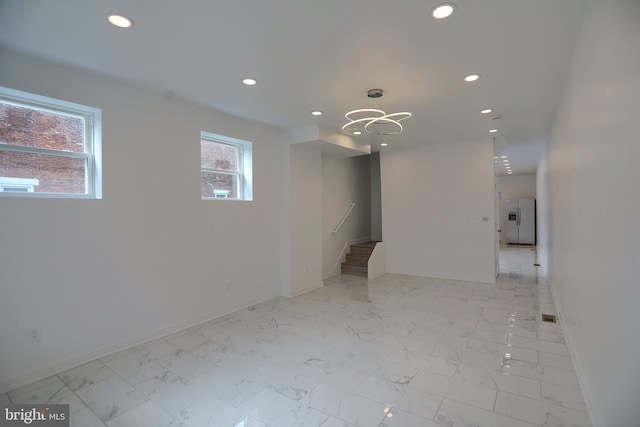 spare room featuring recessed lighting, baseboards, stairway, a chandelier, and light marble finish flooring