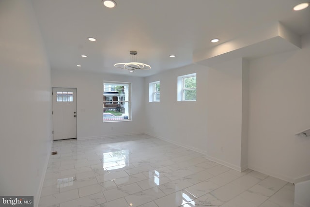 entrance foyer featuring recessed lighting, light marble finish floors, and baseboards