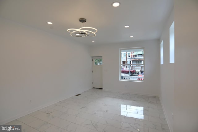empty room featuring recessed lighting, baseboards, a chandelier, and light marble finish floors