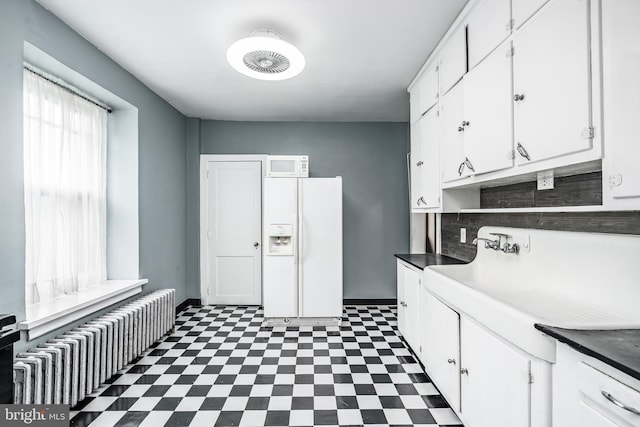 1050 Moravia St, Fountain Hill, PA 18015 - kitchen featuring baseboards, radiator, white appliances, white cabinetry, and tile patterned floors