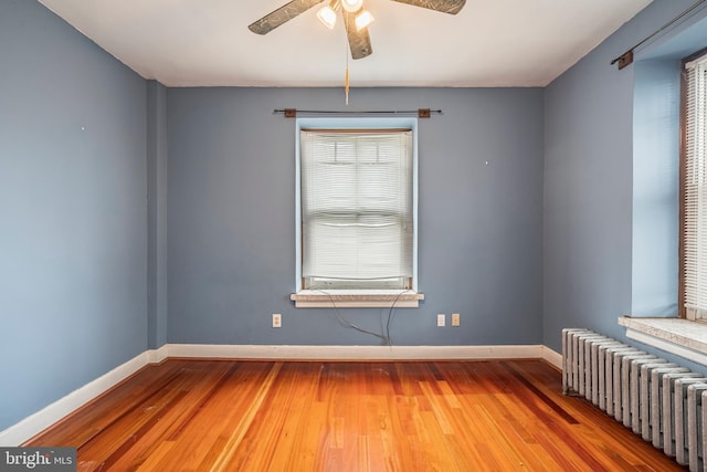 1050 Moravia St, Fountain Hill, PA 18015 - unfurnished room featuring baseboards, radiator heating unit, ceiling fan, and wood finished floors
