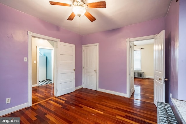 1050 Moravia St, Fountain Hill, PA 18015 - unfurnished bedroom with baseboards, radiator, ceiling fan, and wood-type flooring