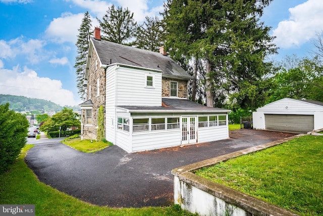 1050 Moravia St, Fountain Hill, PA 18015 - view of front facade with french doors, a chimney, an outdoor structure, a front yard, and a detached garage