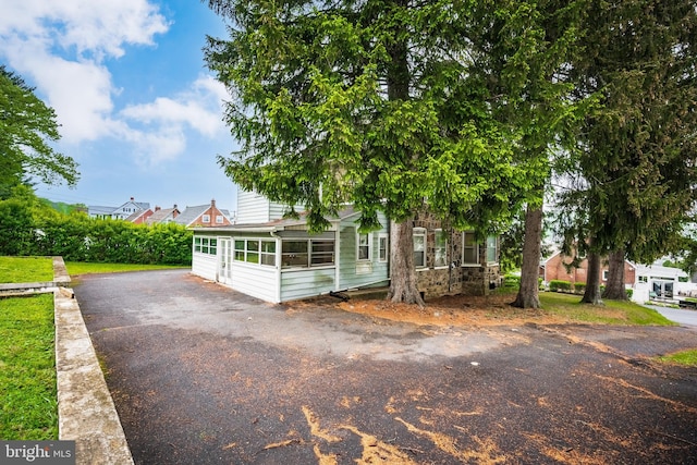 1050 Moravia St, Fountain Hill, PA 18015 - view of front facade with aphalt driveway, a sunroom, and stone siding