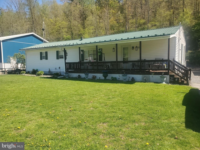 back of house with a yard, metal roof, and a porch