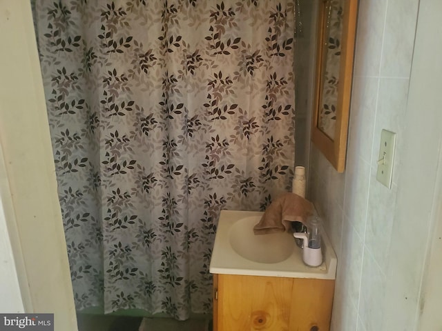 bathroom featuring tile walls, vanity, and a shower with shower curtain
